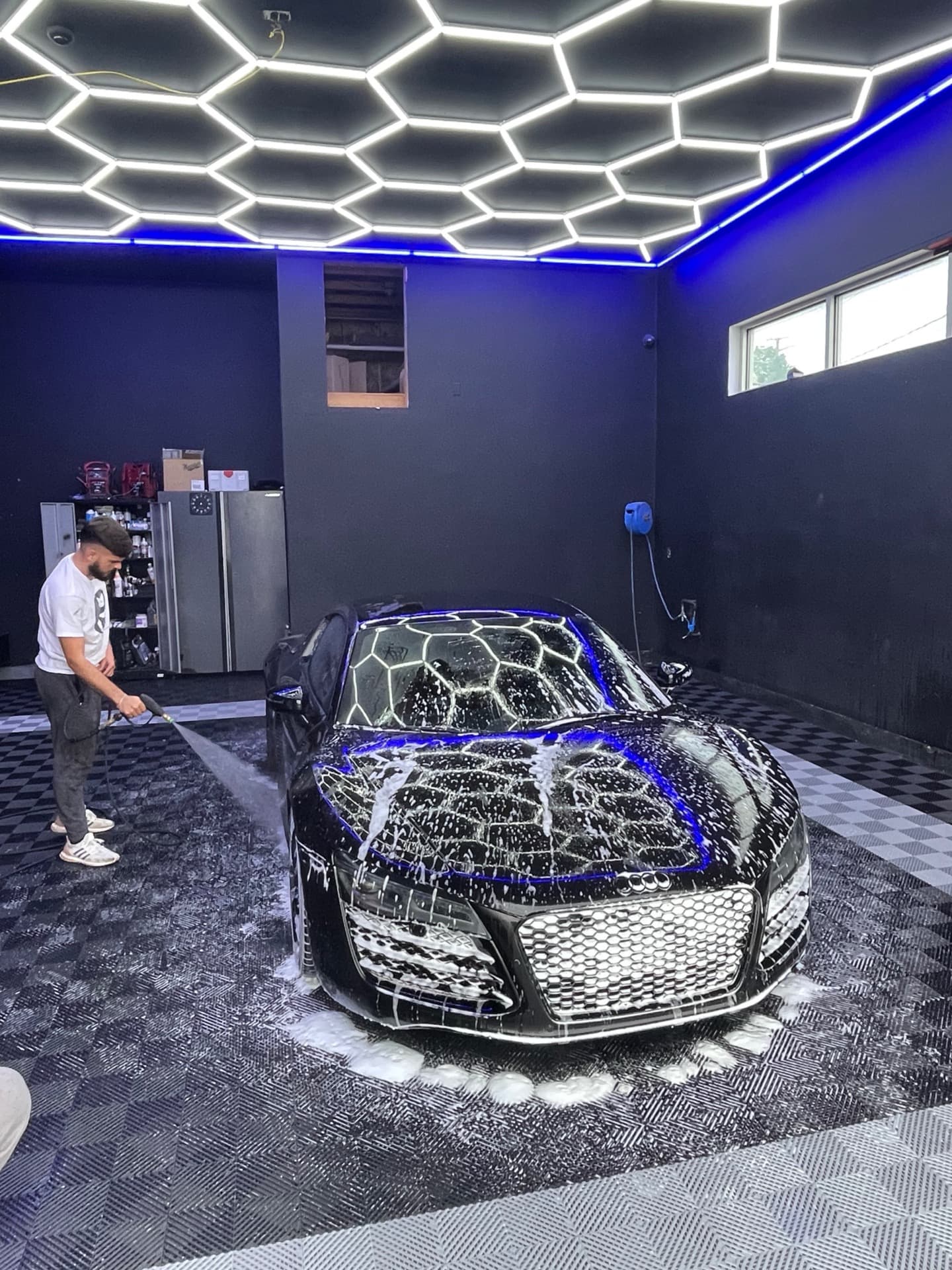 Black Audi R8 professional detailing with hexagonal LED ceiling