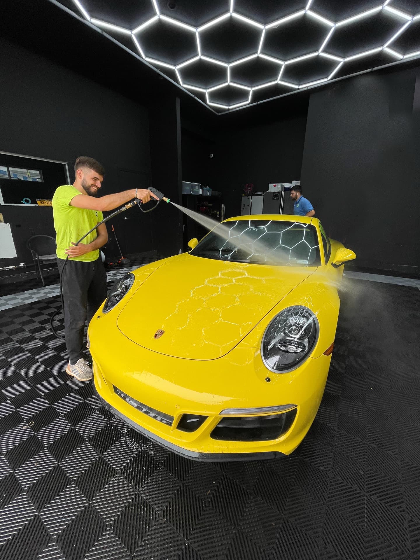 Yellow Porsche 911 being pressure washed