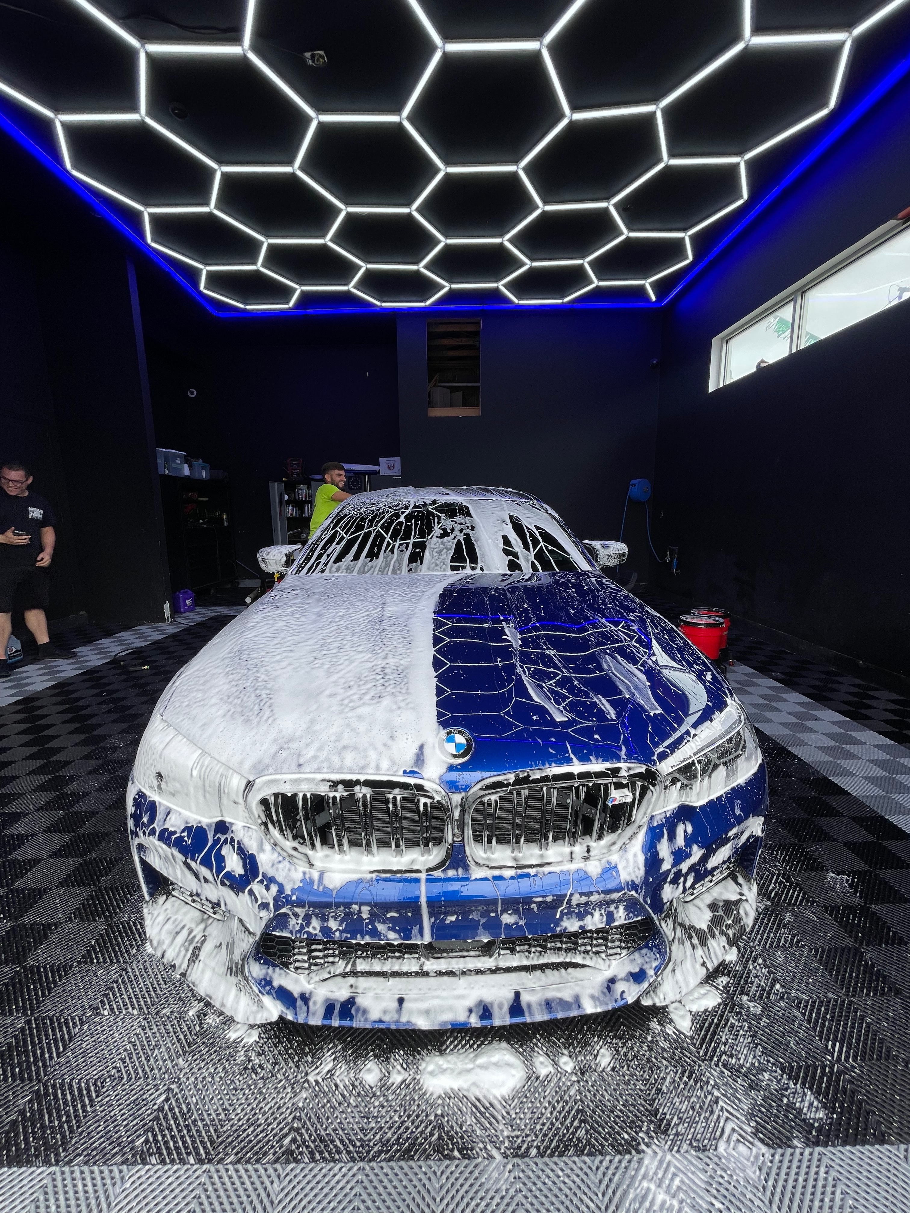 Blue BMW M5 covered in foam wash